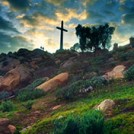 A cross on a hill with clouds