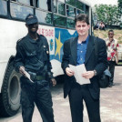 Sasha Chanoff stands next to a hired armed guard in the safe compound outside Kinshasa