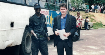 Sasha Chanoff stands next to a hired armed guard in the safe compound outside Kinshasa