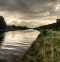 A river, a grassy bank and some dark clouds